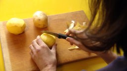 Das Bild zeigt Kartoffeln die geschält werden.