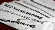 Versicherungsscheine mit Sicherheitsnadel verbunden