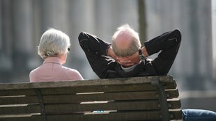 Ein älteres Ehepaar sitzt auf einer Bank