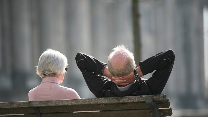 Ein älteres Ehepaar sitzt auf einer Bank