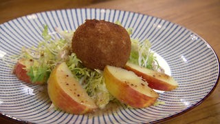Das Bild zeigt den fertigen gelben Frisée Salat, eine Ziegenkäse-Krokette und Apfelscheiben