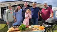 Das Bild zeigt Björn Freitag mit Familie Familie Ohlemann und dem Grill-Weltmeister Oliver Sievers.
