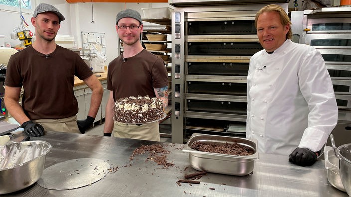 In ihrer Familienbäckerei zeigen Christian (l) und Thomas Weißert (m) Björn Freitag (r) die Besonderheiten der Grillagetorte.