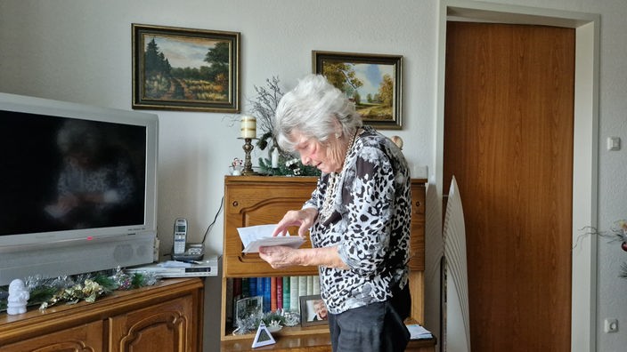 Ilse Barchnitzki liest Briefe im Wohnzimmer
