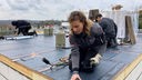 Handwerkerin arbeitet auf dem Dach