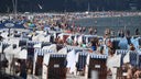 Ein Ostsee-Strand voller Menschen und Strandkörbe.