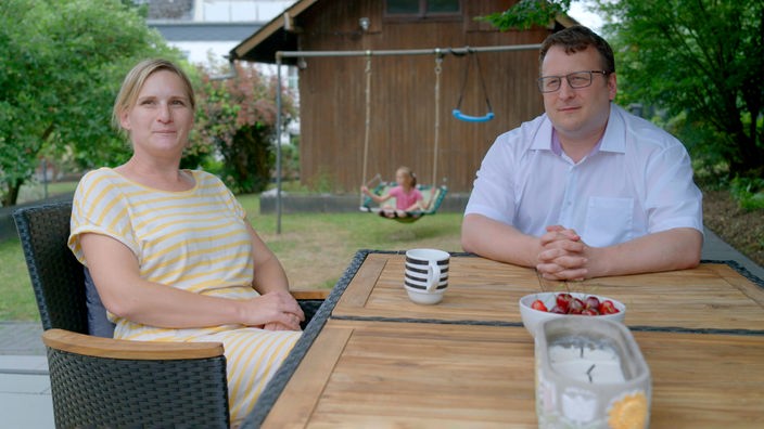Ehepaar Henrich sitzt am Gartentisch.