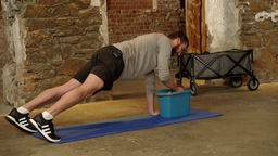 Das Bild zeigt einen Mann bei einer Sportübung.