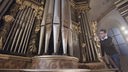 Orgelbauer vor einer historischen Kirchenorgel