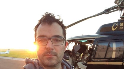 Produzent Jörg Siepmann macht vor einem Helikopter ein Selbstportrait