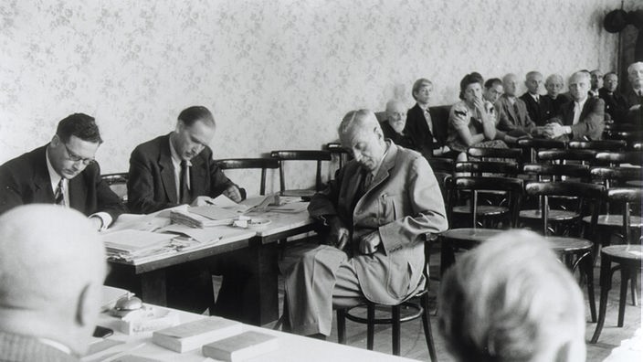 Fritz Thyssen aus einem schwarzweißen Foto an einem Tisch sitzend