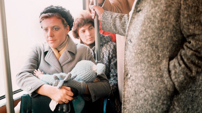 Marie-Luise Marjan 1973 mit Kind im Arm in einem Bus sitzend