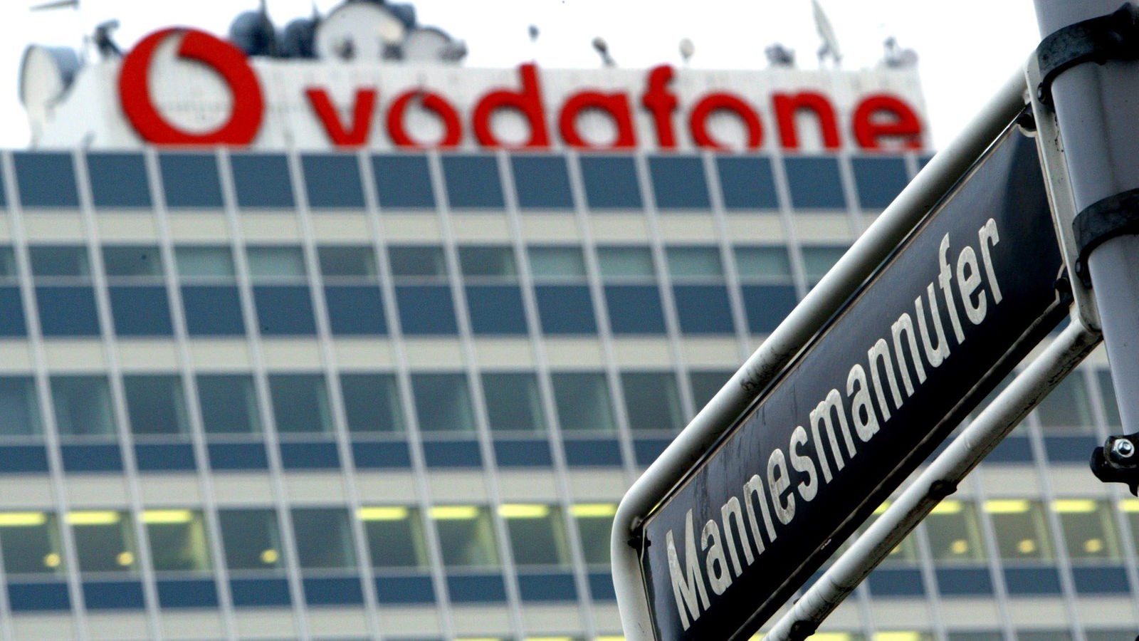Ein Straßenschild mit dem Namen "Mannesmannufer" vor der ehemaligen Konzernzentrale, jetzt mit "Vodafone"-Schriftzug