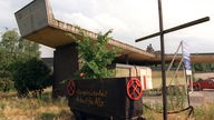 Eine Lore mit einem schwarzen Kreuz vor dem Tor des ehemaligen Krupp-Stahlwerks Rheinhausen