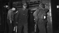 Bergleute beim Verlassen des Grubenaufzuges in einer Kohlenzeche 