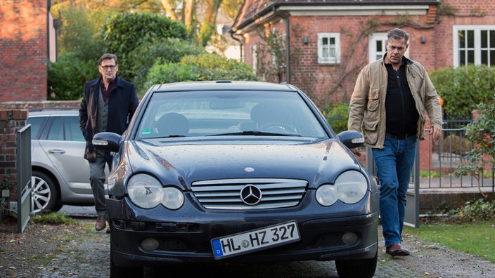 Lars (Ingo Naujoks, l.) und Finn (Sven Martinek, r.) treffen beim Haus ihrer Vorgesetzten ein und finden das beschädigte Unfallauto