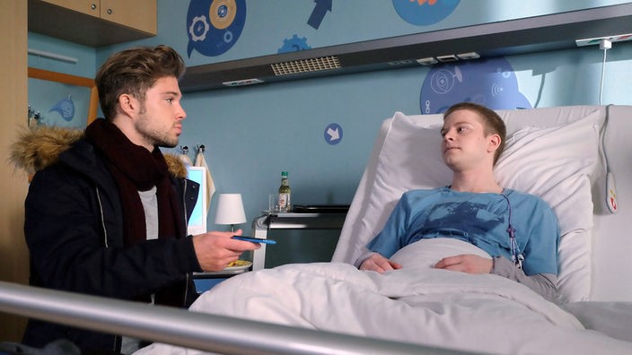 Kris Haas (Jascha Rust, li.) verbringt seinen freien Tag an Dominiks Bett, der gerade wieder eine Chemotherapie bekommt.