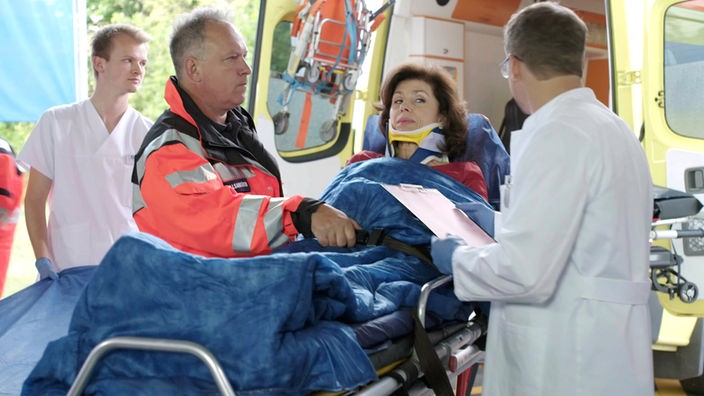 Prof. Patzelt (Marijam Agischewa, 2.v.r.) kommt nach einem Motorrad-Unfall ins Klinikum.
