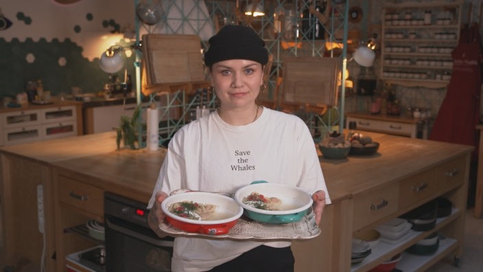 Foodbloggerin präsentiert stolz ihr fertig zubereitetes Essen auf einem Tablett 