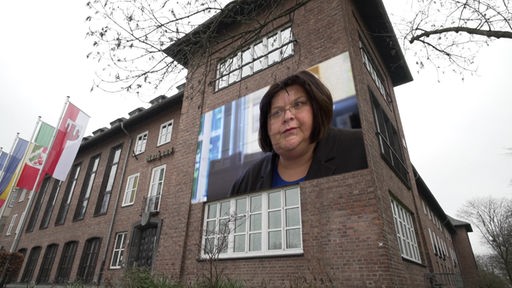 Portrait von Frau auf Poster an einer Hausfassade