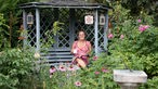 Kai Judith Wetzel sitzt in ihrer Gartenlaube. 