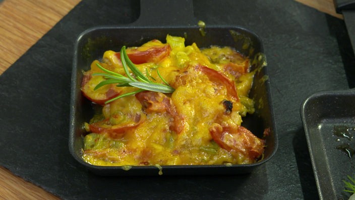 Das Bild zeigt das Gericht "Fruchtiges Curry-Hähnchen mit Cheddar" im Raclette Pfännchen.