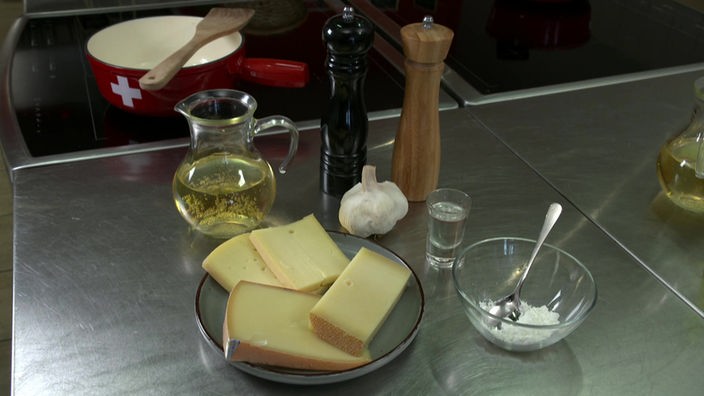 Das Bild zeigt die Zutaten des Gerichts "Käsefondue traditionell Schweizer Art".