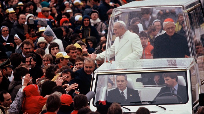 Der Papst fährt in einem panzerglasgeschützten Auto durch eine Menschenmenge