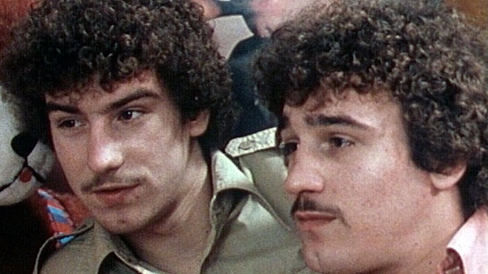 Foto aus den 1970er Jahren: Zwei junge Männer mit Minipli-Frisuren