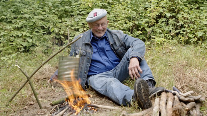 Ein Mann sitzt am Lagerfeuer