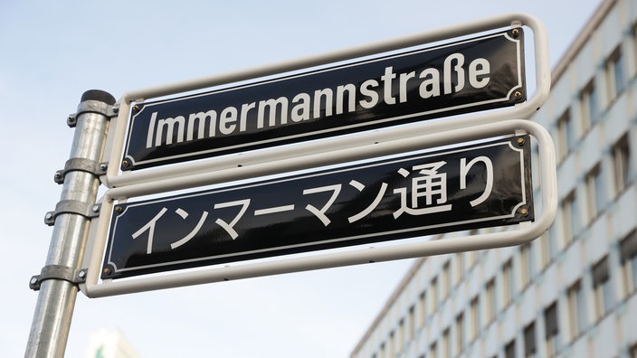 Ein Straßenschild in der Düsseldorfer Immermannstraße mit japanischen Schriftzeichen