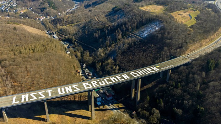 Schriftzug Lasst uns Brücken bauen auf einer gesperrten Autobahn- Brücke der A45