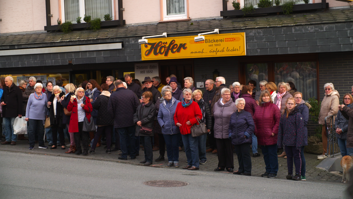 Eine Menschenmenge steht vor einer Bäckerei