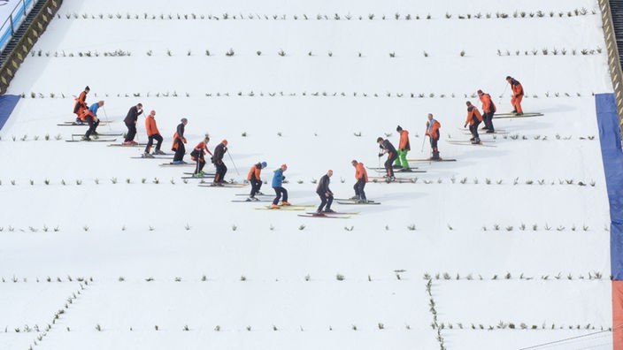 Skiläufer präparieren die Landezone