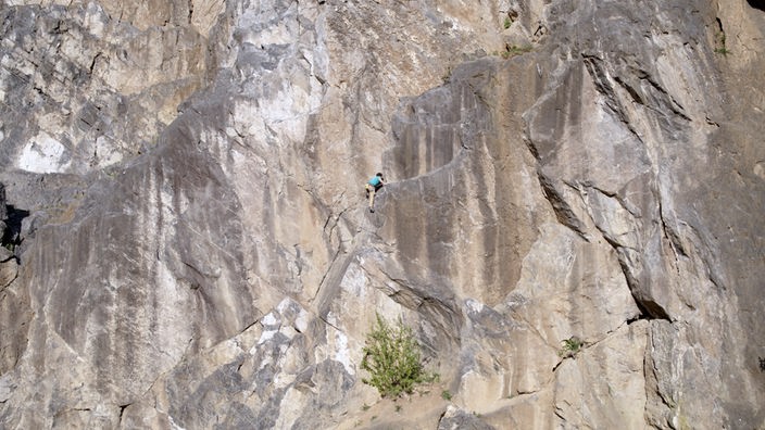 Ein Kletterer in einer großen Felswand