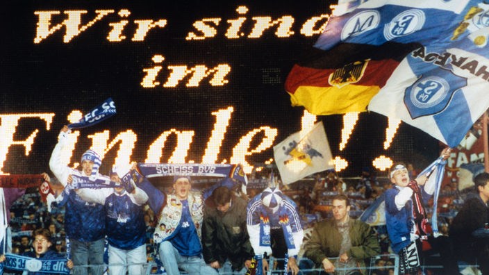 Schalke-Fans jubeln, auf Anzeigetafel steht Wir sind im Finale