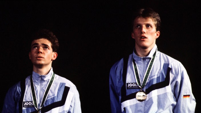 Zwei Männer in Sportkleidung mit Goldmedaille um den Hals