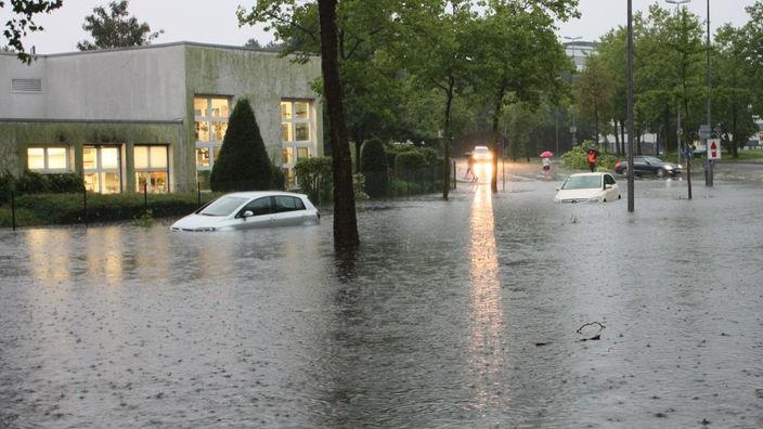 Zwei Autos stehen am 28.07.2014 auf einer überfluteten Straße in Münster. 
