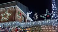 Ein Haus strahlt vor lauter Lichterketten in der Nacht.