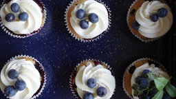 Blaubeer-Cupcakes mit Zitronen-Frosting auf einer Platte