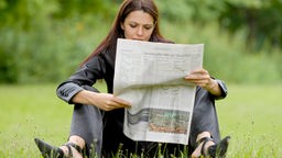 Eine Frau liest Zeitung