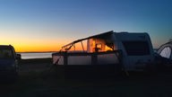 Wohnwagen am Strand beim Sonnaufgang