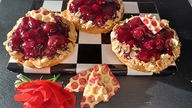 Kirsch-Tartelettes von Marcel Seeger auf einem Teller mit Schachbrettmuster