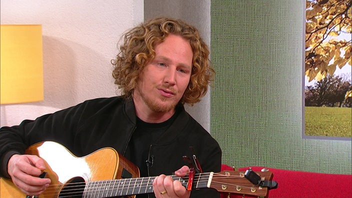 Sänger Michael Schulte mit Gitarre im Hier und heute-Studio