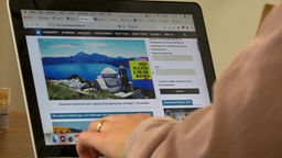 Ein Mann surft im Internet auf einer Reiseplattform