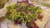 Angerichteter Salat aus Fenchel mit grünem Spargel, Orangen und Avocado sowie gebratener Hühnerleber