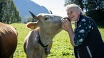 Agnes Jaud wird von einer Kuh "geküsst". 