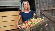 Alina Schmittgen mit ener Kiste Äpfel.