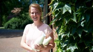 Andrea Strothlüke mit Milchflaschen in der Hand. 