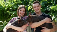 Anna und Bruzder Jonas mit Schweinen auf dem Arm